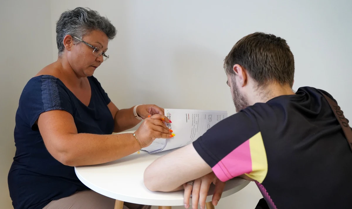 Un jeune échange avec une professionnelle autour d’un document.